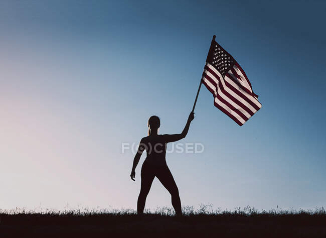 Femme tenant un drapeau américain — Photo de stock
