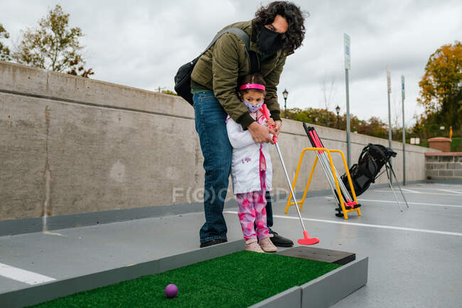 Padre e hija jugando mini golf en traje de Halloween - foto de stock