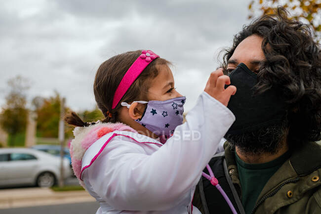Menina em traje de Halloween com o pai vestindo máscara protetora — Fotografia de Stock