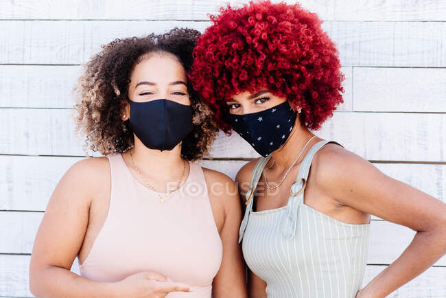 Two latin women  with afro hair wearing face masks - foto de stock