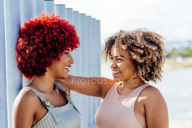 Dos mujeres latinas con pelo afro hablando - foto de stock