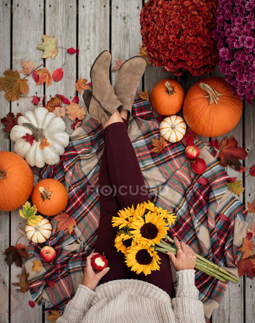 Overhead view of woman's legs and torso surrounded by fall items. — Stock Photo
