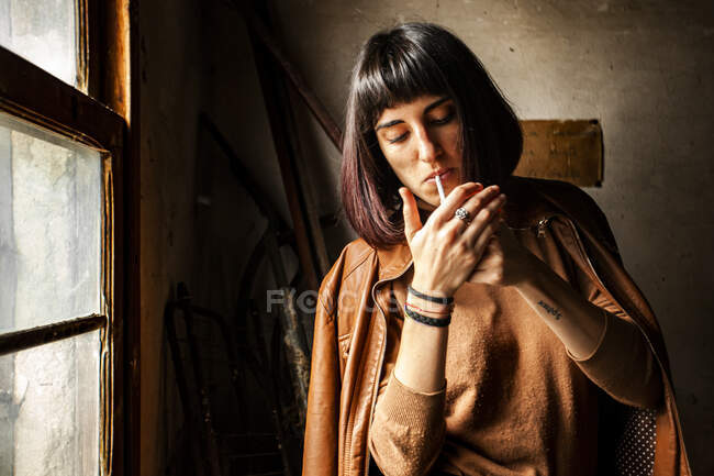 Портрет брюнетки, закуривающей сигарету — стоковое фото