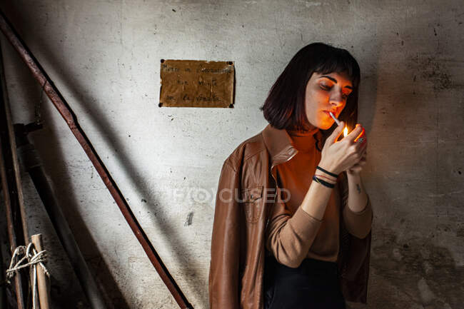 Portrait d'une fille brune allumant une cigarette — Photo de stock
