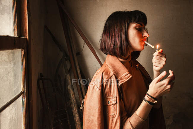 Portrait of a Brunette girl lighting a cigarette — Stock Photo