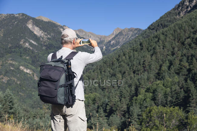 Mid old caucasian tourist man take a picture from Spanish Pyrenees mountain with mobile phone — Stock Photo