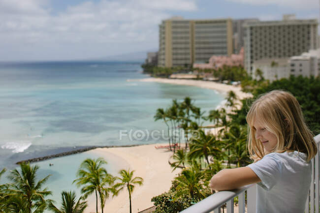 Ragazza sorridente gode Waikiki vista sull'oceano dal balcone dell'hotel (tilt shift) — Foto stock