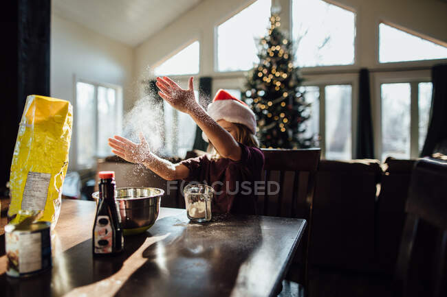 Boy doing Christmas baking and playing with flour — Stock Photo