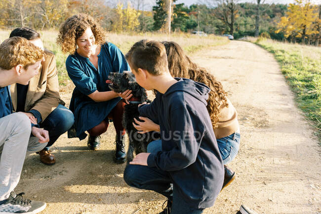 Una familia de cinco juntos en un paseo con su perro - foto de stock