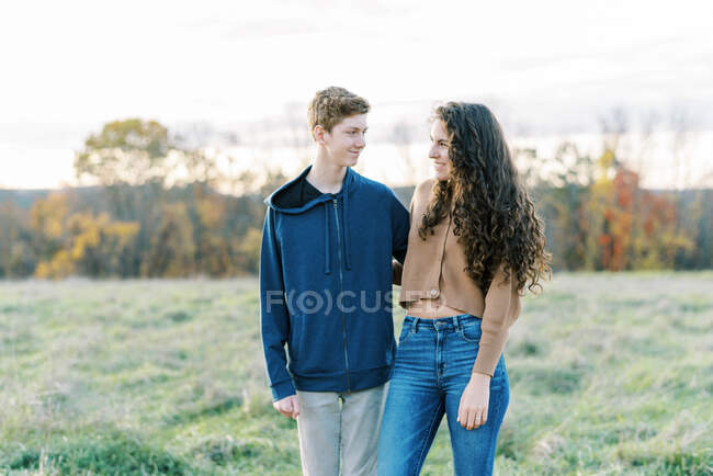 Two teenage siblings standing together smiling — Stock Photo