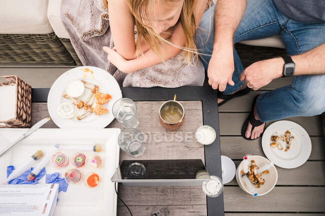 Familie, die draußen sitzt und an einem Zoom-Essen mit scharfer Soße teilnimmt — Stockfoto