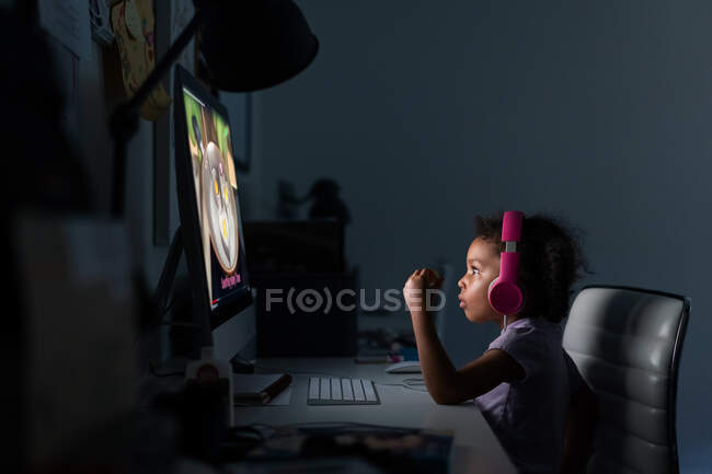 Junges Mädchen mit Kopfhörern benutzt Computer zu Hause — Stockfoto