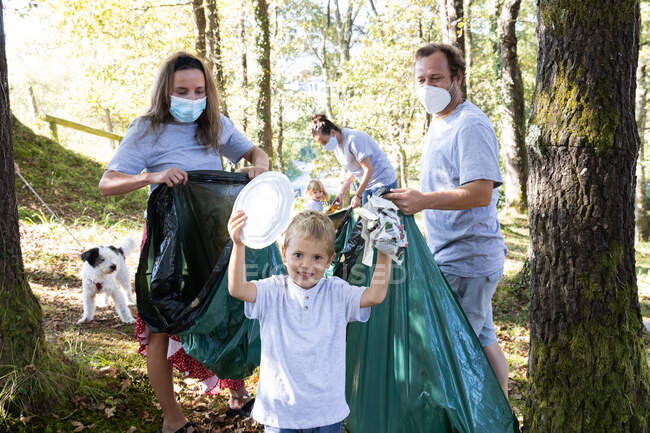 Сім'ї, що збирають сміття в лісі. Концепція переробки — стокове фото