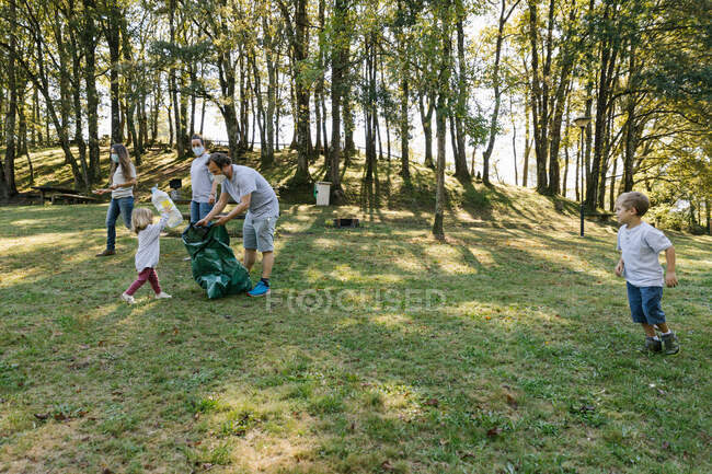 Gruppo di famiglie di volontari nel parco che aiutano a preservare l'ambiente — Foto stock