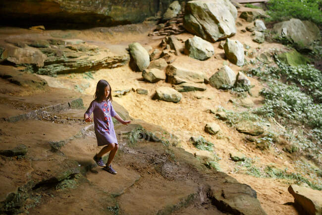 Маленький ребенок спускается по каменной лестнице в солнечном ущелье из песчаника — стоковое фото
