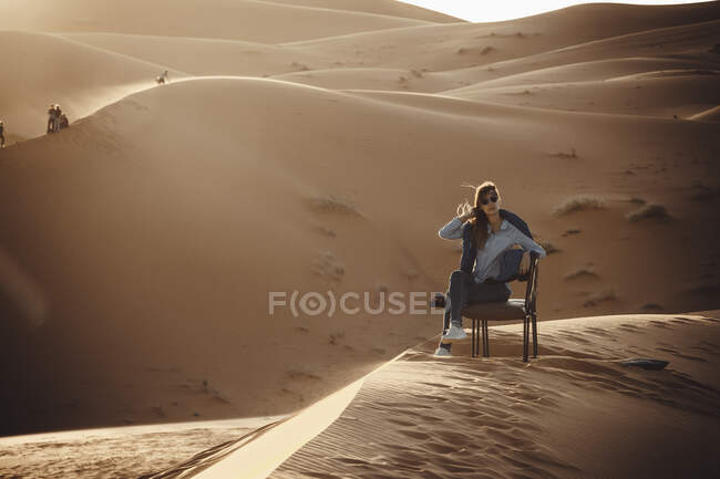 Woman sit down at Sahara desert — Stock Photo