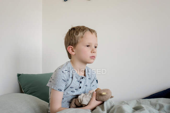 Young boy waking up in his bed in the morning at home — Stock Photo