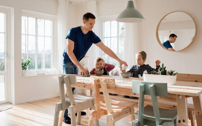 Father helping his kids make breakfast and getting ready for school — Stock Photo