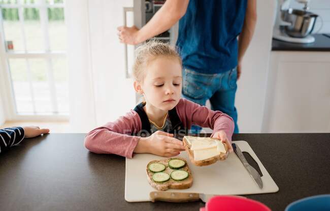 Jeune fille aider son père faire le déjeuner à la maison avant l'école — Photo de stock