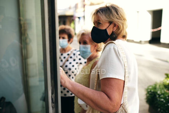 Women window-shopping and walking with friends — Stock Photo