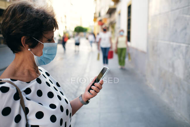 Жінка дивилася на мобільний під час прогулянки. — стокове фото