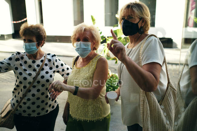 Зрелые дамы окна покупки с кофе в руке — стоковое фото