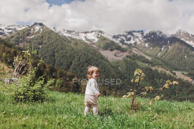 Маленька дівчинка, яка дивилася на гори, обернулася — стокове фото