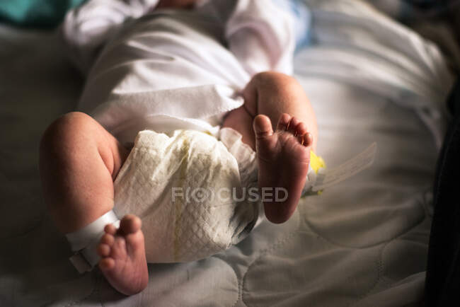 Um bebê recém-nascido chuta seus pés. — Fotografia de Stock