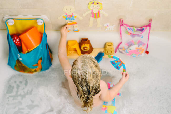 Ein kleines Mädchen spielt mit Spielzeug in der Badewanne. — Stockfoto
