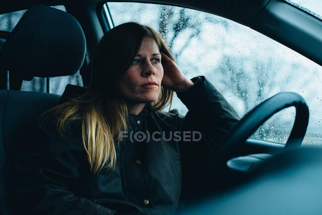 A woman sits in a car. — Stock Photo