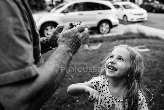 Una niña mira a su abuelo. - foto de stock