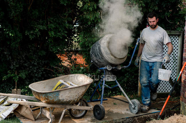A man mixes some cement. — Stock Photo