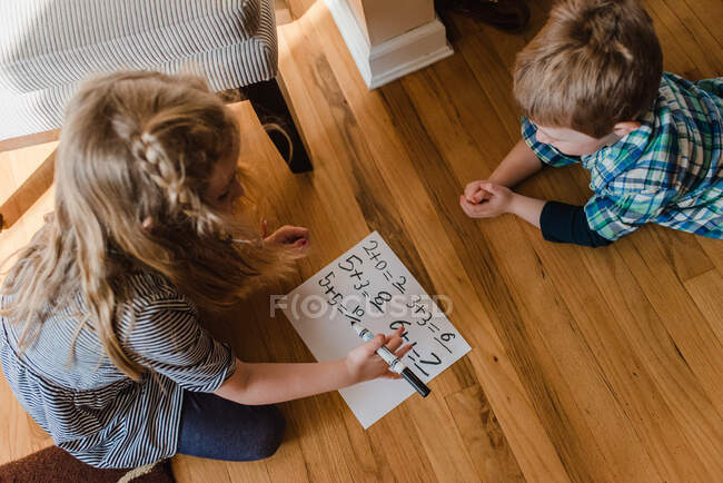 Un ragazzo e una ragazza praticano problemi di matematica. — Foto stock
