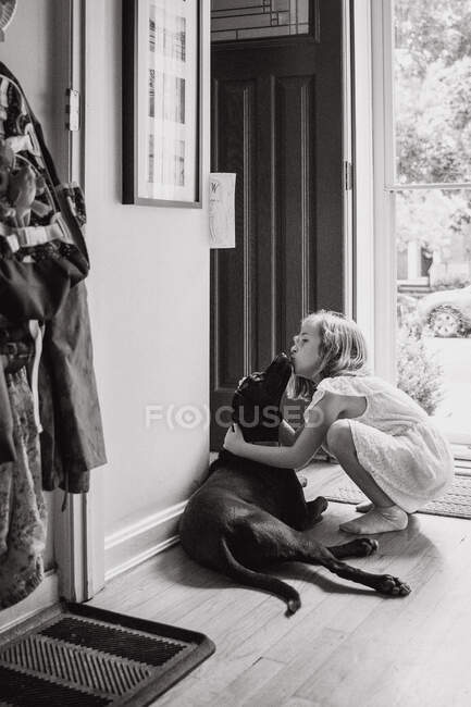 Ein kleines Mädchen bekommt einen Kuss von ihrem Hund. — Stockfoto