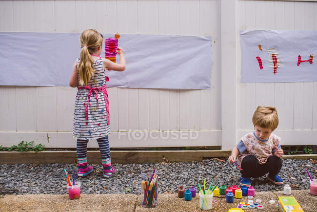 Двое детей рисуют снаружи. — стоковое фото