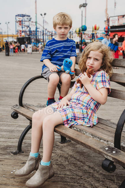 Duas crianças sentam-se num banco em Coney Island. — Fotografia de Stock