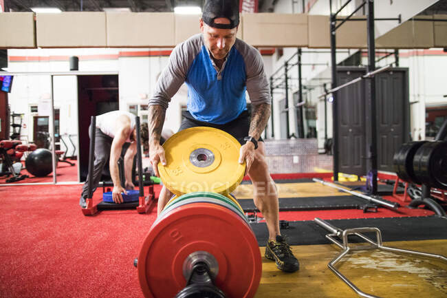 Mann Bodybuilder trainiert im Fitnessstudio mit Personal Trainer — Stockfoto