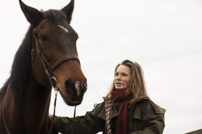 Young horsewoman with a horse outside — Stock Photo