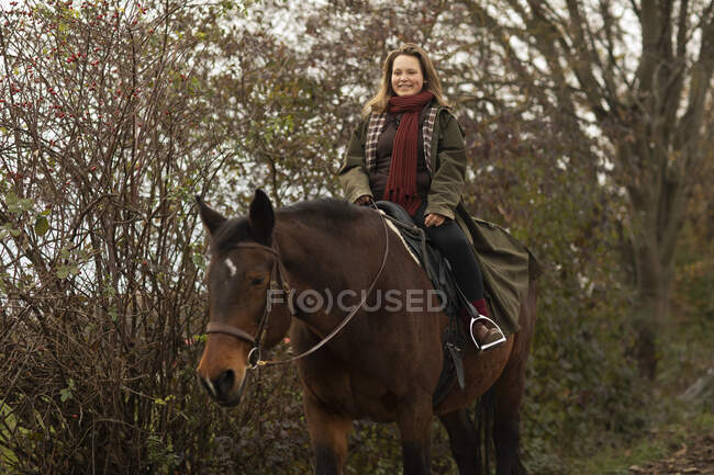 Joven jinete con un caballo fuera a caballo - foto de stock