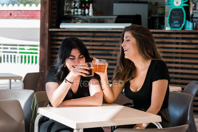 Dos jóvenes están bebiendo cerveza en una terraza de un pub. Estilo de vida, ocio - foto de stock