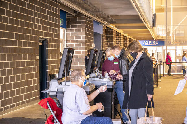 Избиратели, подающие свои бюллетени в счетчики. — стоковое фото
