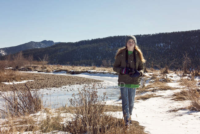 Joven pelirroja chica con cámara explorando en las montañas rocosas - foto de stock
