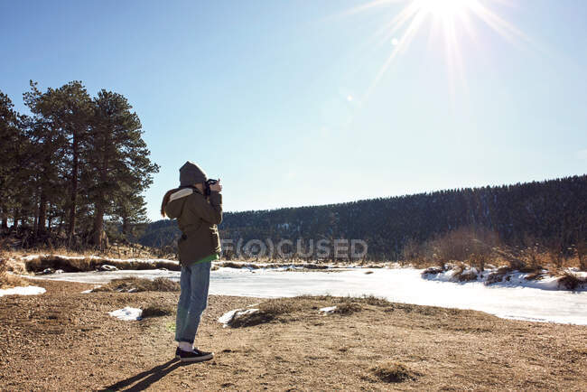 Menina com câmera explorando em montanhas rochosas — Fotografia de Stock
