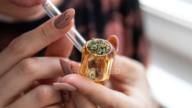 Fille européenne fume de la marijuana à travers un tube en verre. cannabis sm — Photo de stock