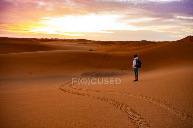 Femme au milieu du désert regardant le lever du soleil — Photo de stock