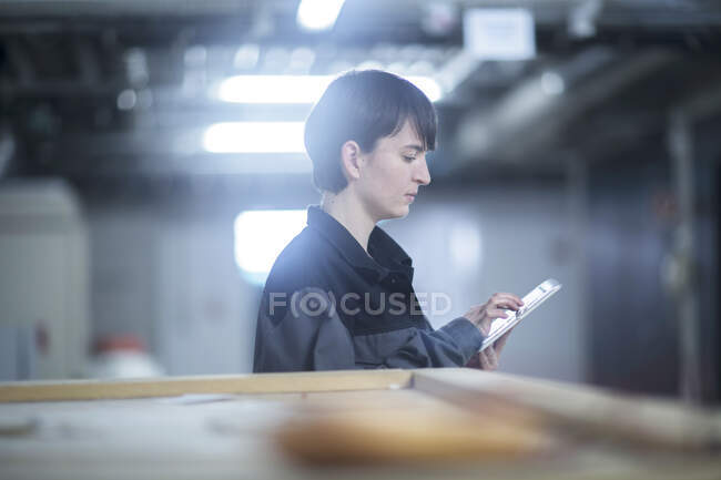 Mulher engenheiro com um dispositivo de verificação e controle — Fotografia de Stock