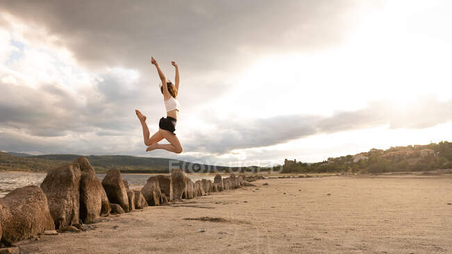 Дівчина стрибає щаслива на морі — стокове фото