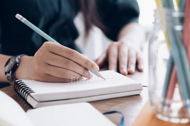 Fermez les mains féminines avec un stylo écrit sur le carnet. Concept d'éducation. — Photo de stock