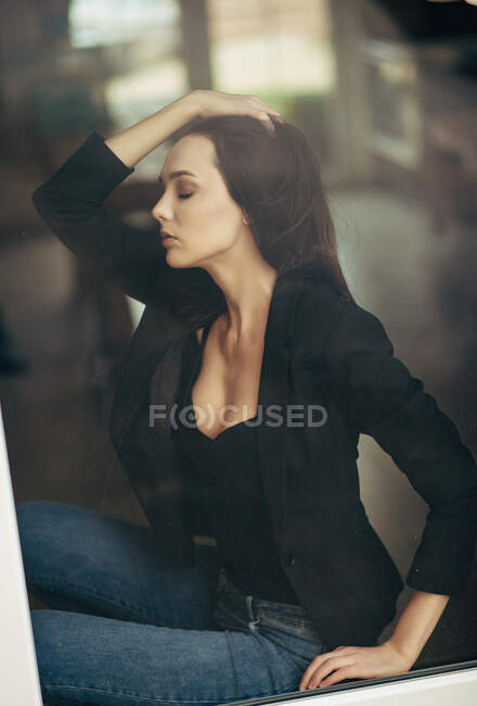 Красива жінка в стильній куртці, що тримає очі закритими вдома . — стокове фото