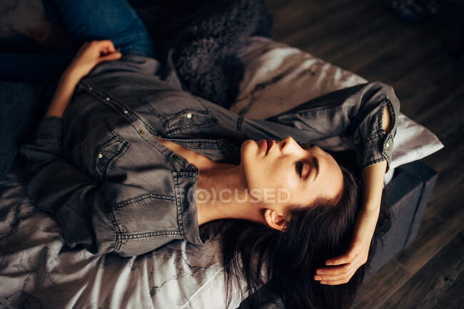 Молода жінка спить і розслабляється в її ліжку — стокове фото